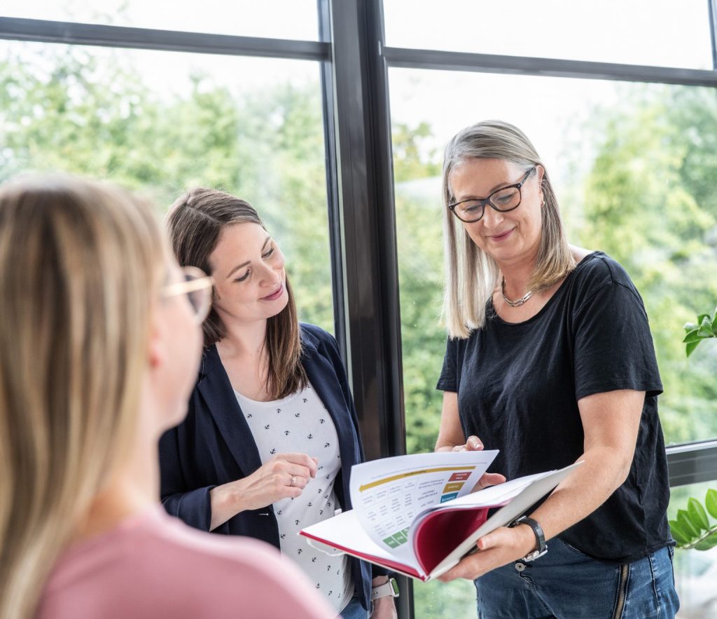 drei Kolleg:innen sind bei der Besprechung der KI basierten Tools von Recruiting Software Beesite